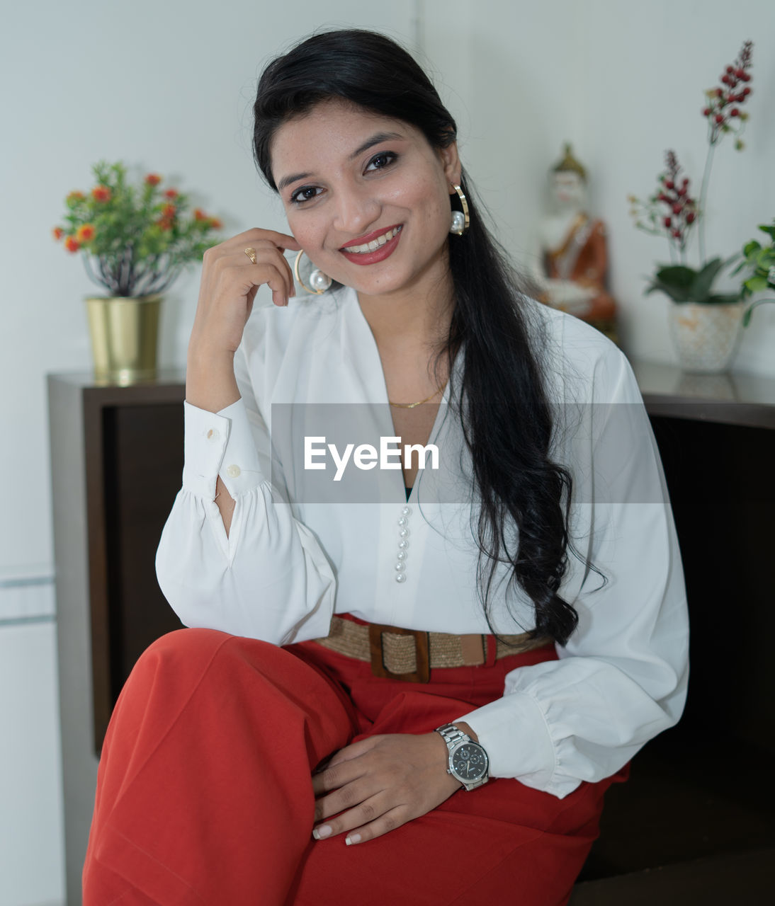 Portrait of a smiling young woman sitting at home