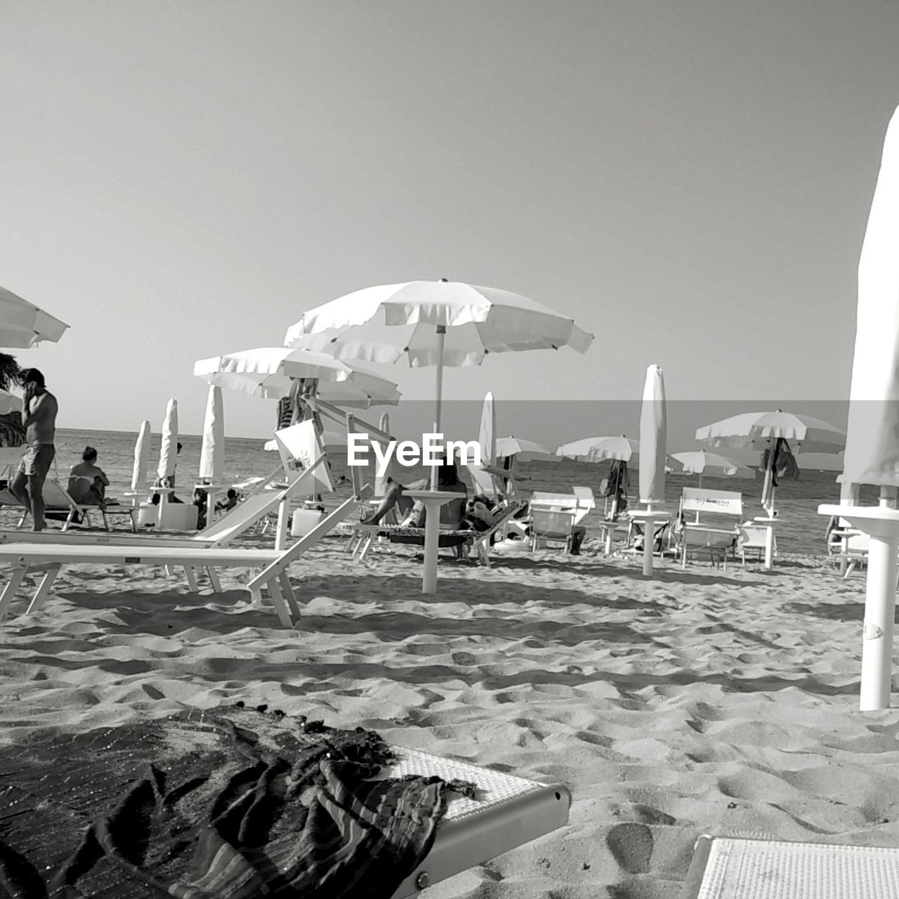 PEOPLE AT BEACH AGAINST CLEAR SKY