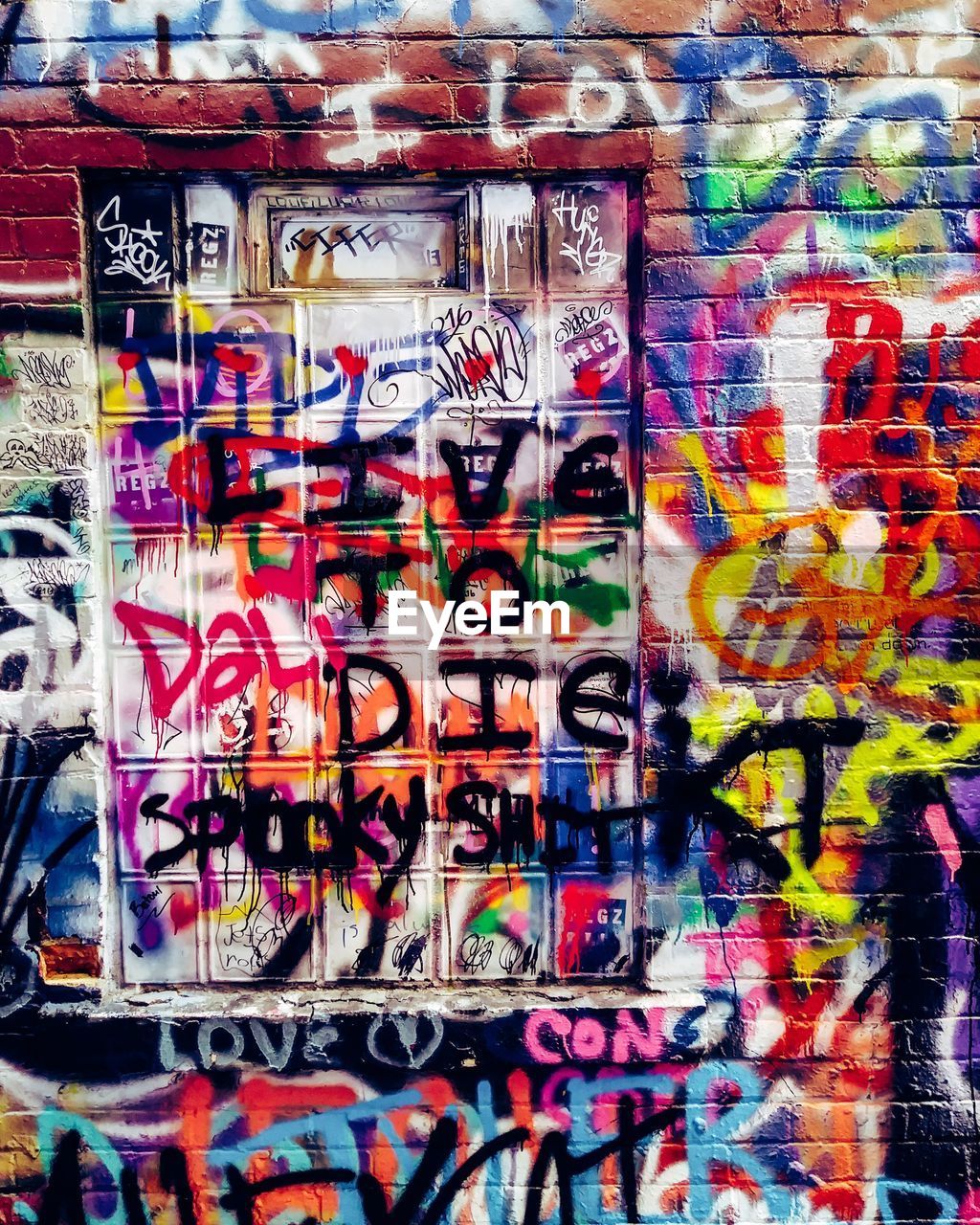 FULL FRAME SHOT OF MULTI COLORED GRAFFITI ON WALL