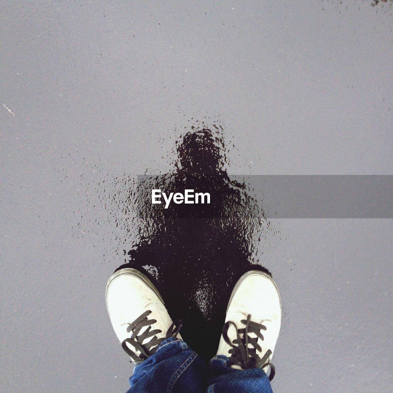 Low section of man standing on wet street during monsoon