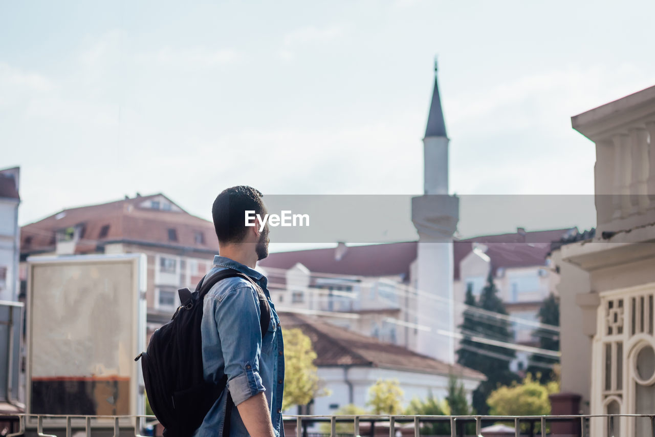 Man standing against buildings in city