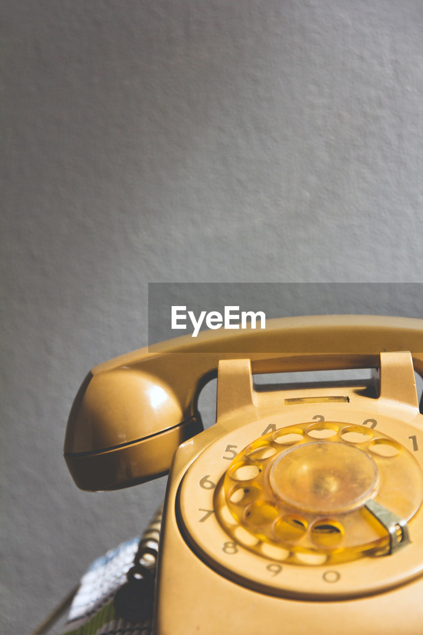 Close up of telephone on table against wall