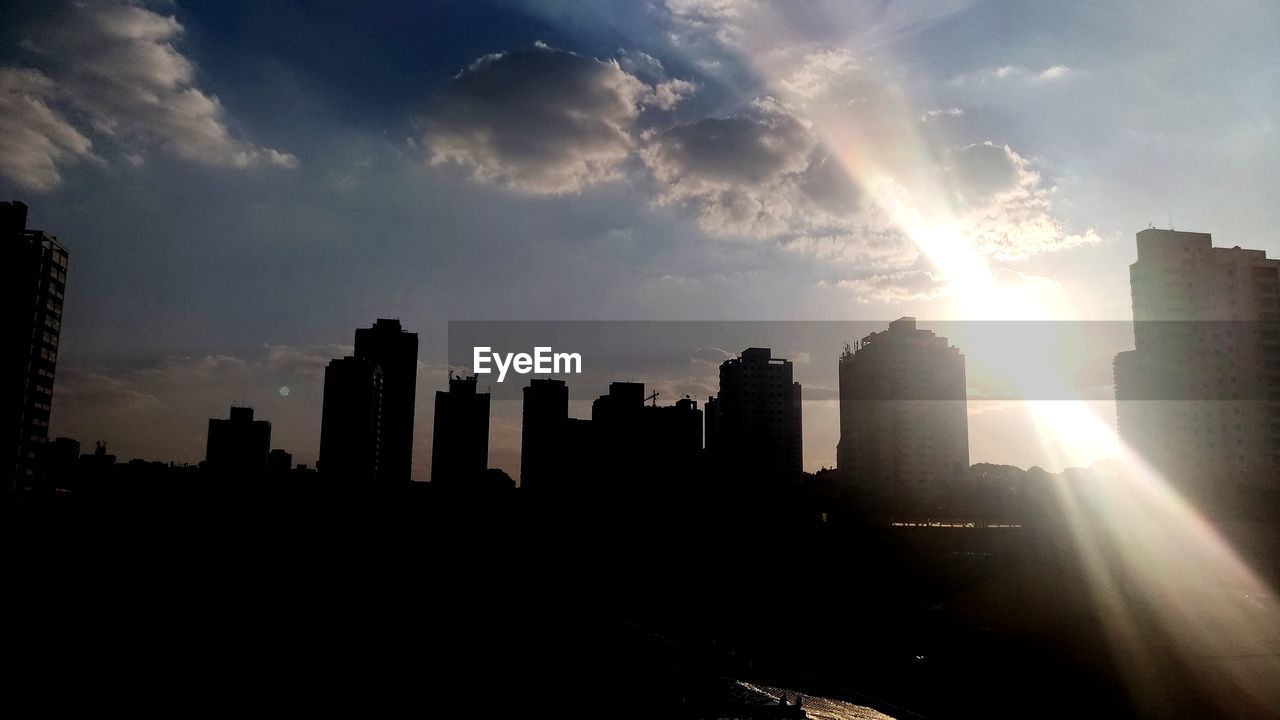 SILHOUETTE BUILDINGS IN CITY AGAINST SKY AT SUNSET