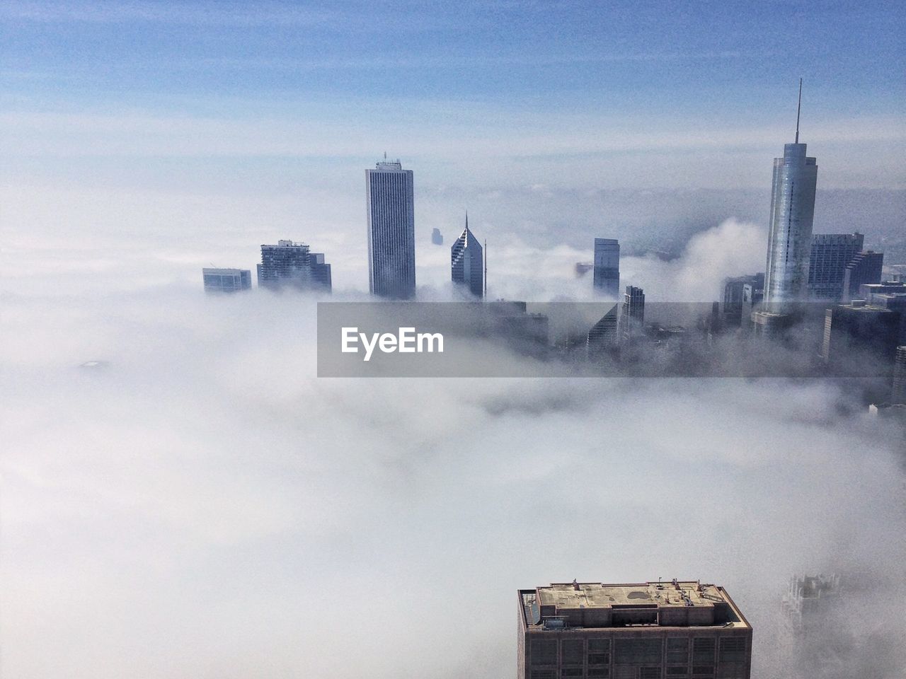Buildings in city against sky during foggy weather
