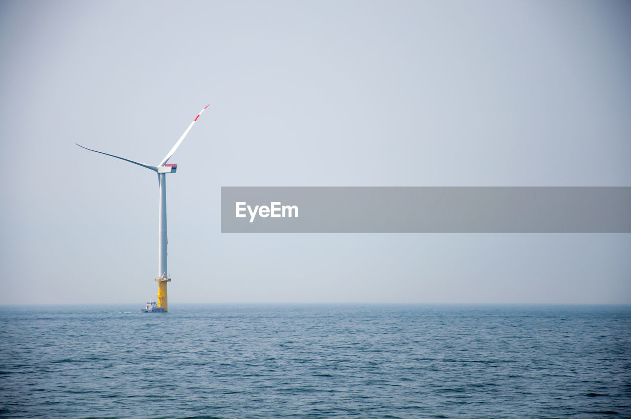 WIND TURBINES IN SEA AGAINST SKY