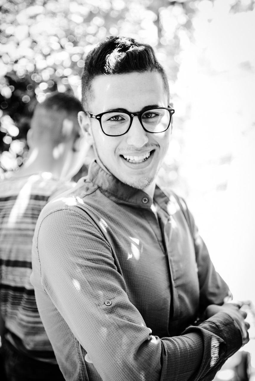 PORTRAIT OF YOUNG MAN WEARING EYEGLASSES