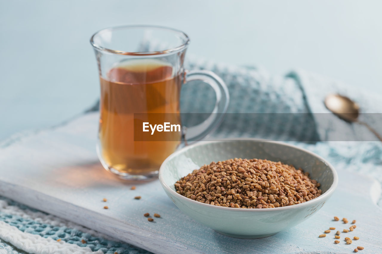 Bowl of fenugreek seeds and egyptian fenugreek yellow tea or methi dana drink