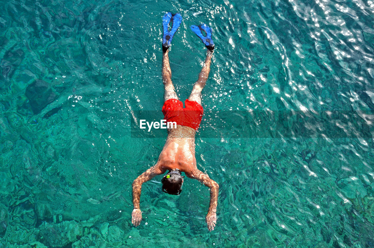 Directly above shot of shirtless man swimming in sea