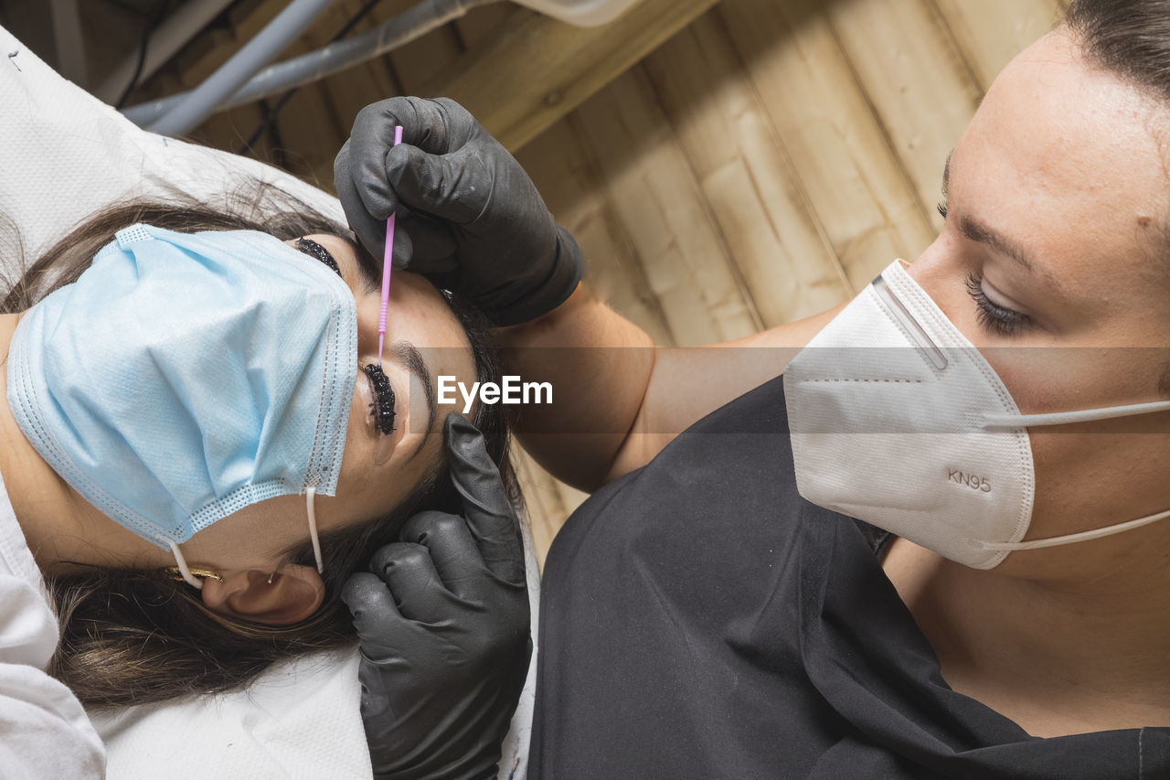 Beautician working with mask and protective screen for the virus covid