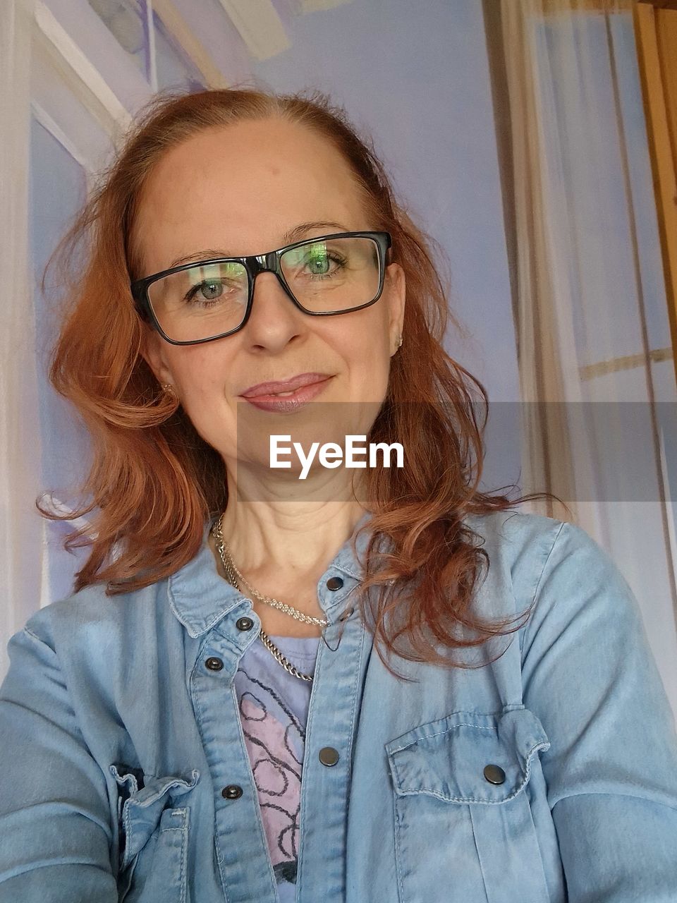 one person, women, adult, lying down, young adult, glasses, portrait, relaxation, lifestyles, indoors, human face, human hair, smiling, casual clothing, blond hair, happiness, leisure activity, person, high angle view, headshot, hairstyle, lying on back, emotion, clothing, female, long hair, skin, looking at camera, redhead