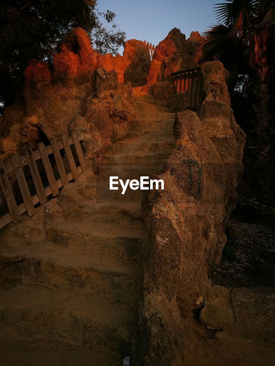 WALKWAY AMIDST ROCKS AGAINST SKY