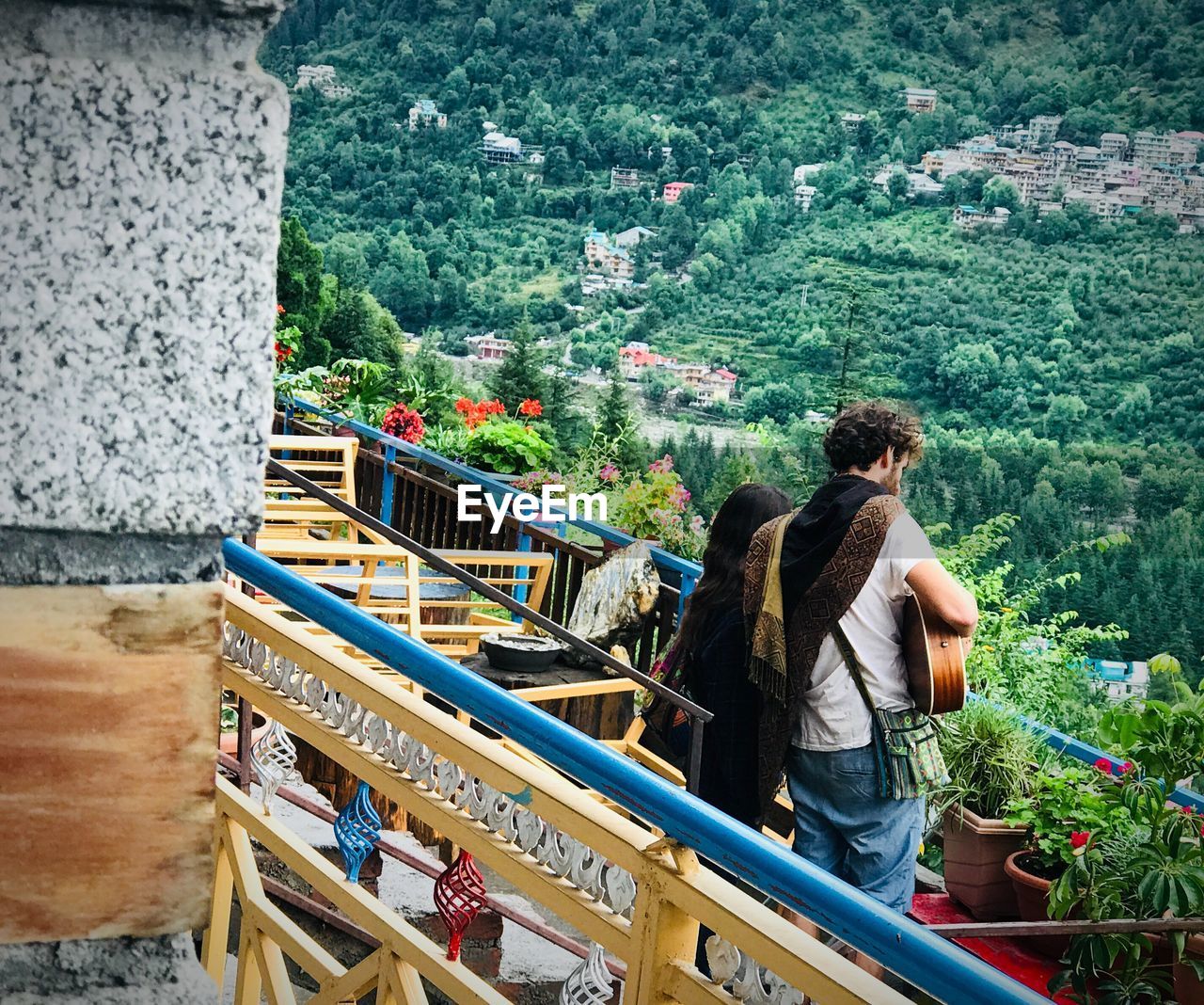 Side view of couple standing at restaurant against trees