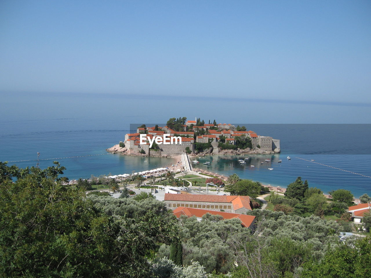 High angle view of buildings by sea against clear sky