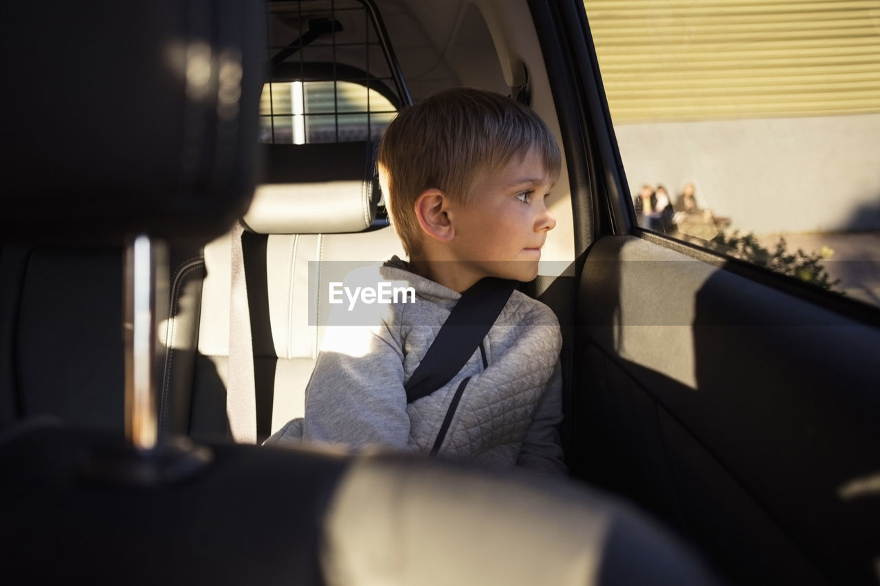 Boy sitting in electric car looking through window