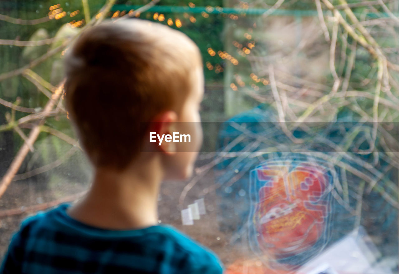 PORTRAIT OF BOY LOOKING THROUGH GLASS IN WATER