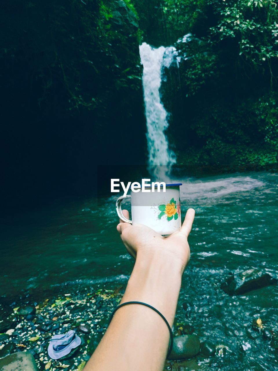 Optical illusion of woman filling water in cup