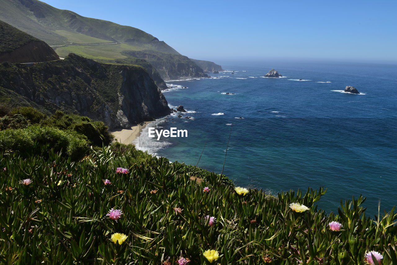 Scenic view of sea and mountains against sky