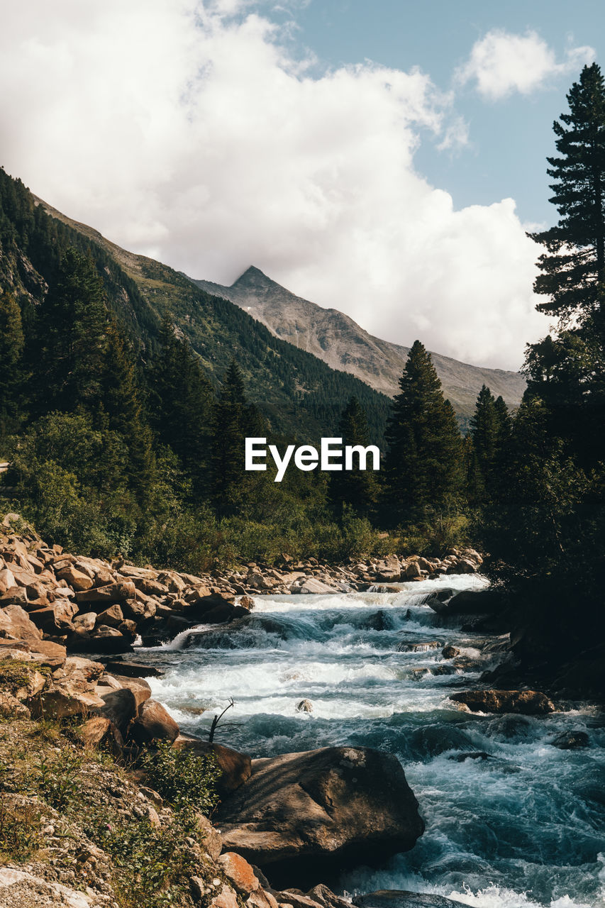 Scenic view of river amidst mountains against sky