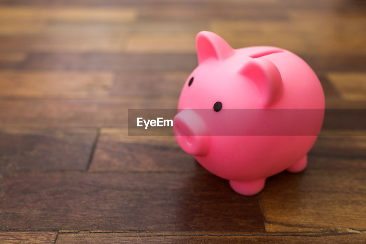 Pink piggy bank on wooden desk