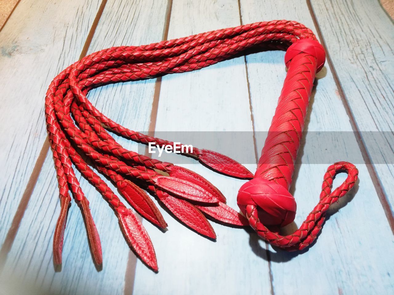 HIGH ANGLE VIEW OF RED ROPE TIED ON TABLE