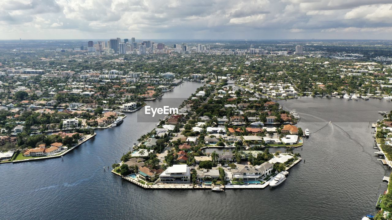 HIGH ANGLE VIEW OF SEA AND BUILDINGS AGAINST SKY