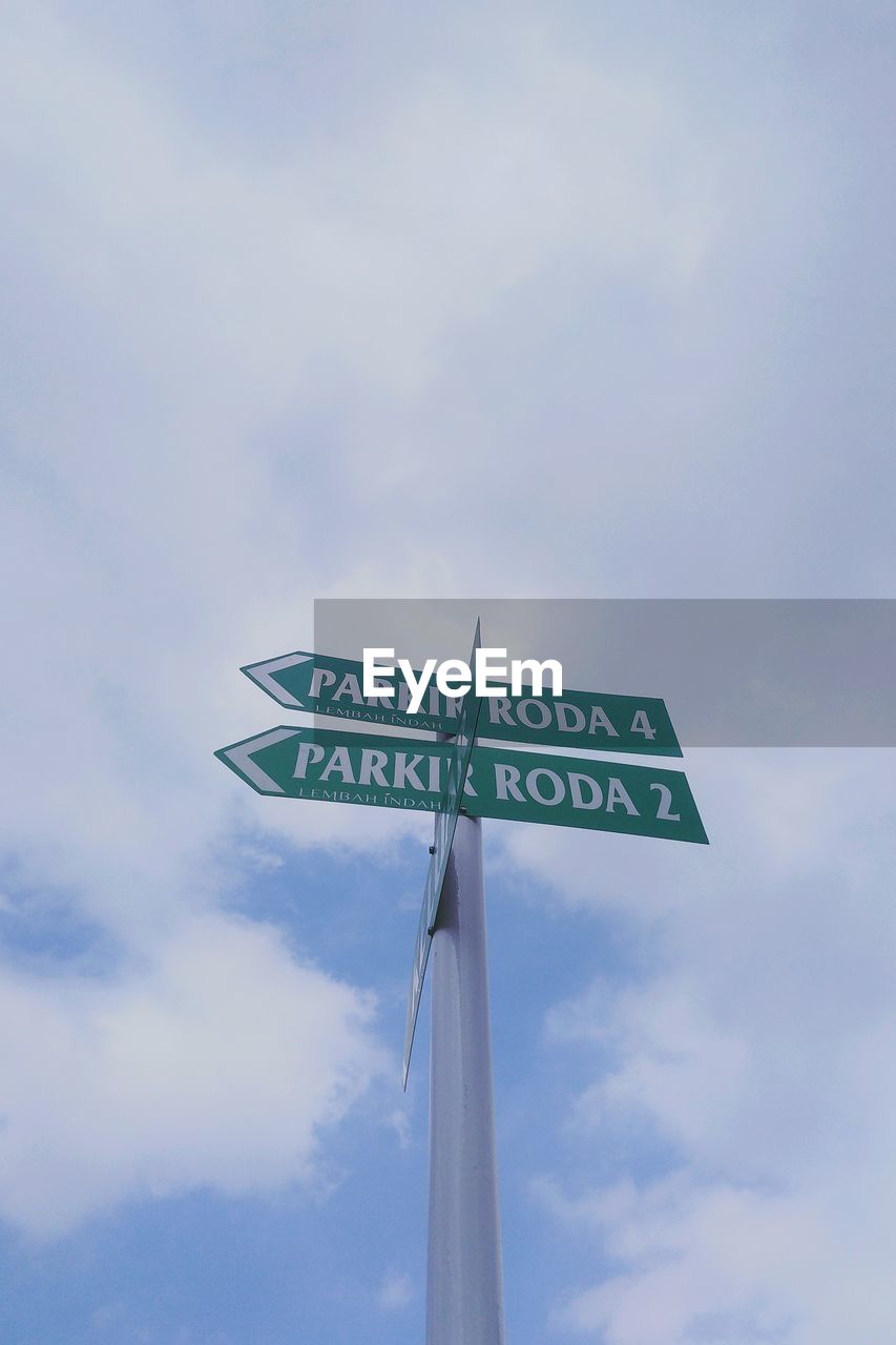 Low angle view of road sign against sky