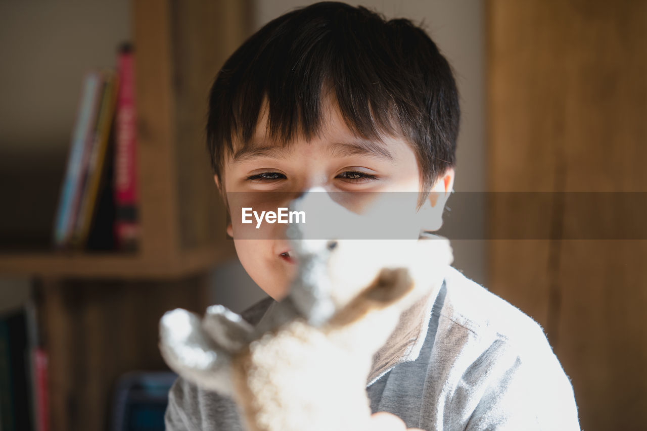 Cute boy holding toy at home