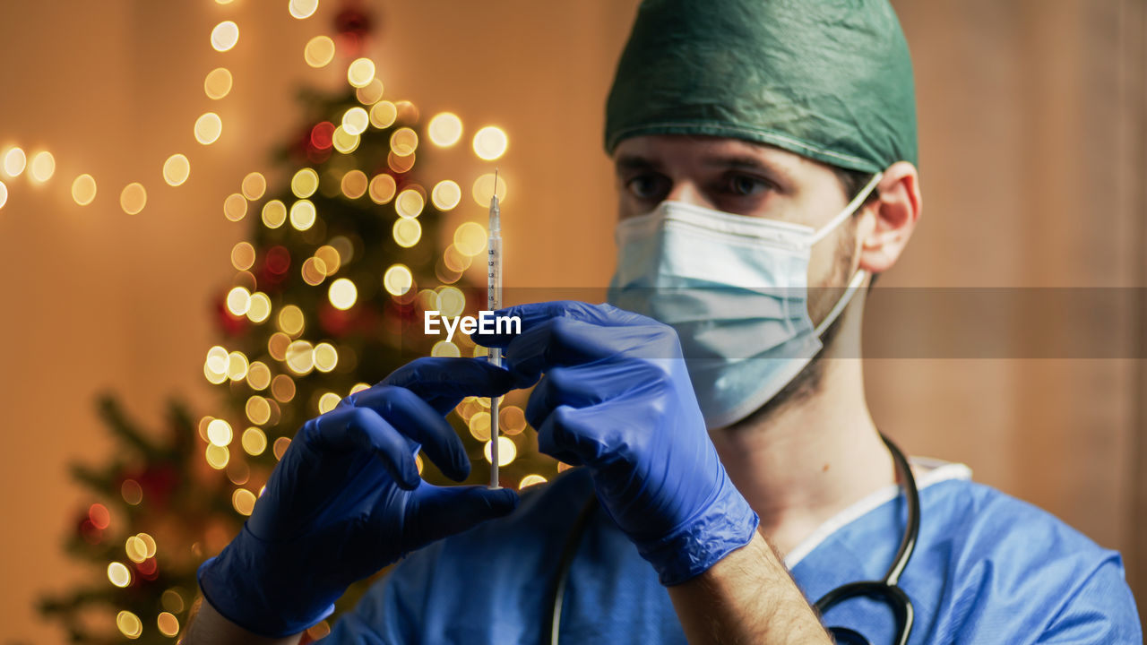 Doctor with vaccine on christmas background