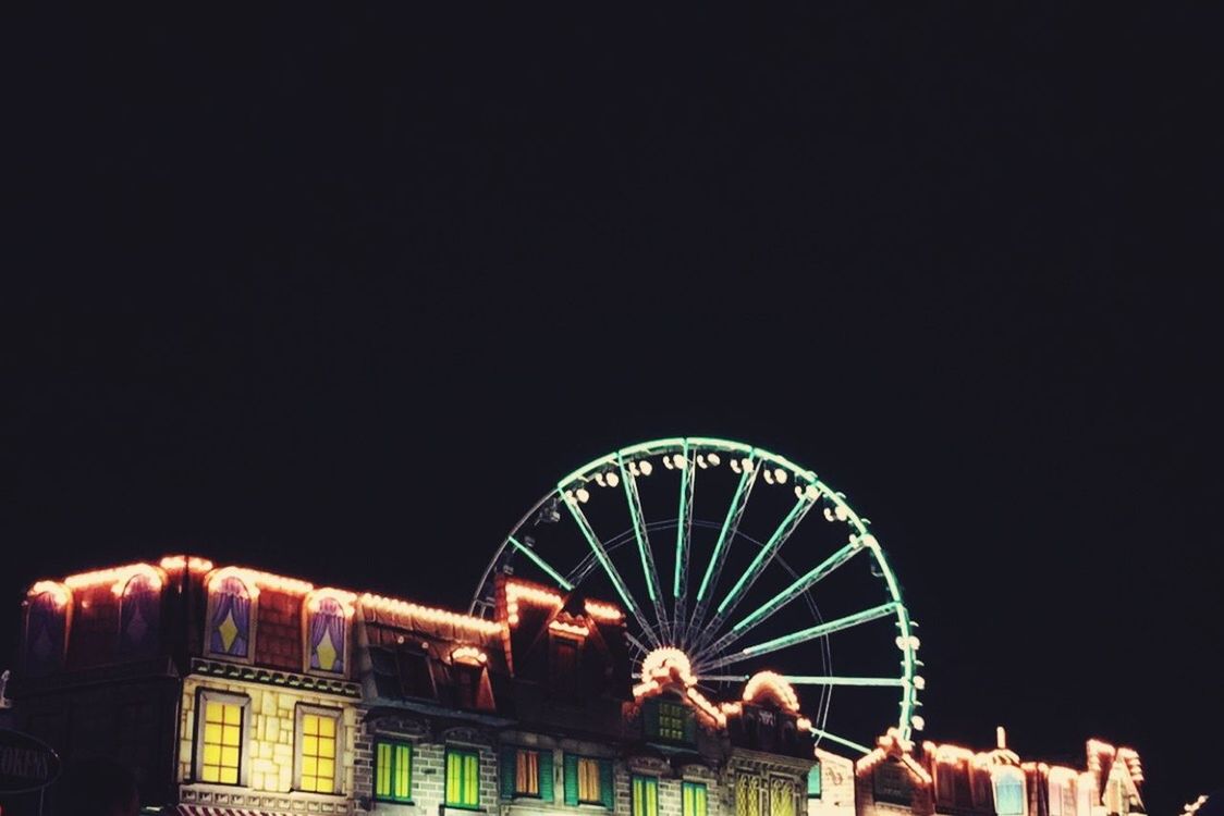 LOW ANGLE VIEW OF ILLUMINATED FERRIS WHEEL AT NIGHT