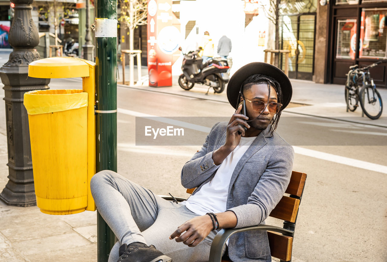 FULL LENGTH OF MAN SITTING ON STREET