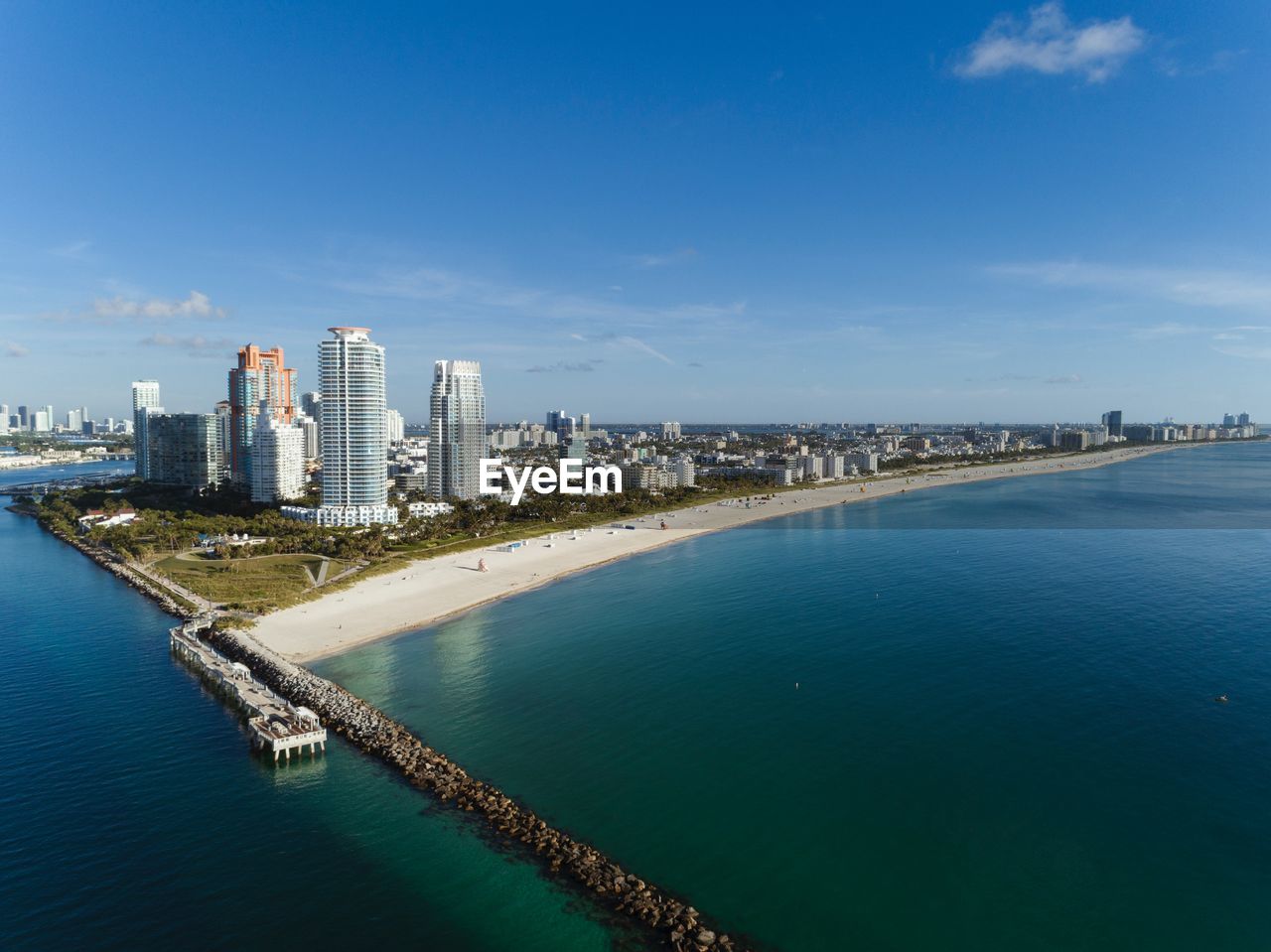 Scenic view of sea by buildings against blue sky