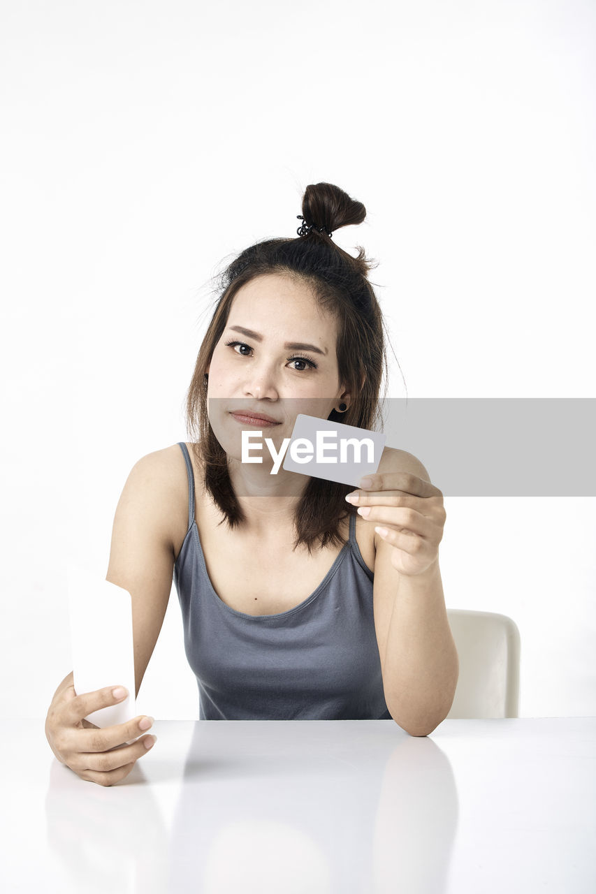 PORTRAIT OF YOUNG WOMAN HOLDING SMART PHONE