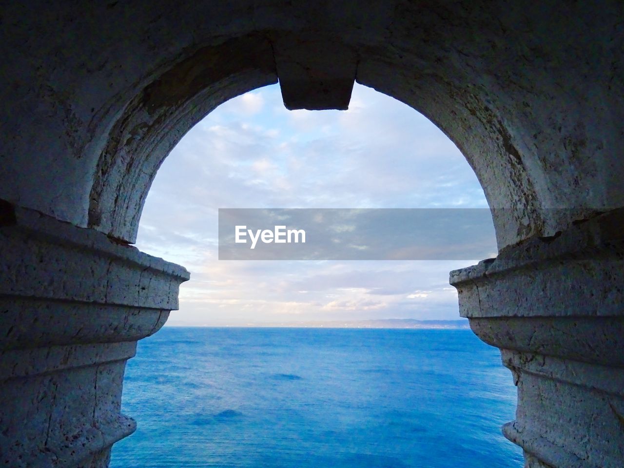Scenic view of sea seen through arch 