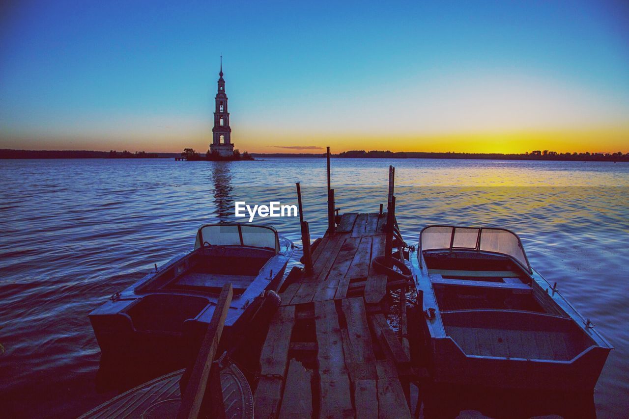 WOODEN POSTS IN SEA AGAINST CLEAR SKY