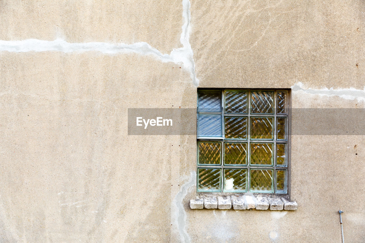 LOW ANGLE VIEW OF HOUSE WINDOW COVERED WITH BUILDING