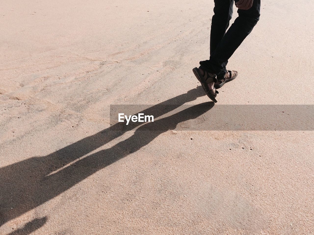 Low section of man with shadow on floor