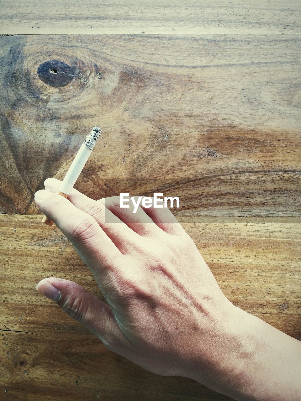 CLOSE-UP OF MAN HOLDING CIGARETTE