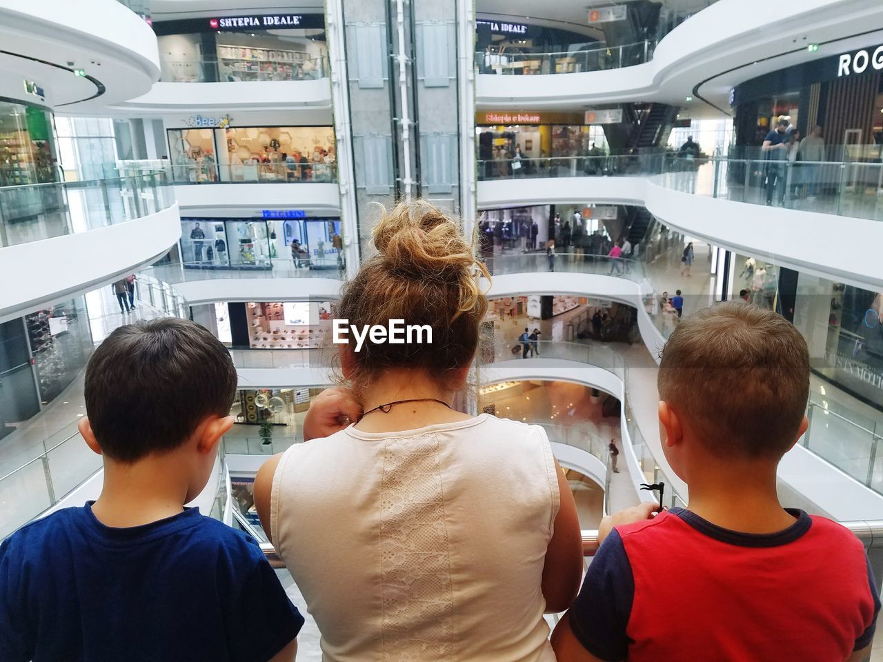 Rear view of friends standing in shopping mall