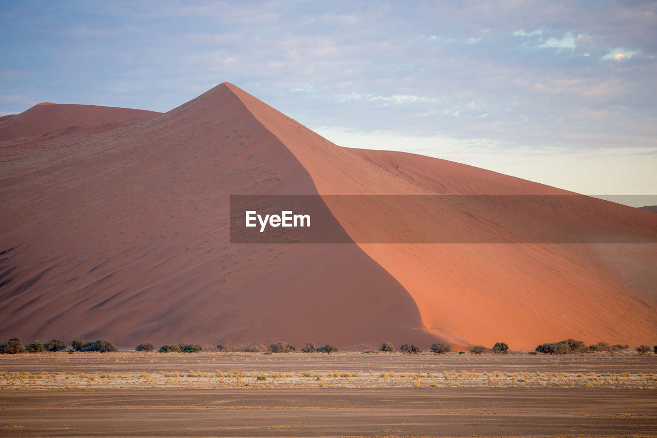 View of desert against cloudy sky