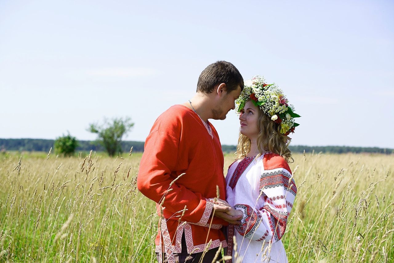 SIDE VIEW OF SIBLINGS STANDING ON FIELD