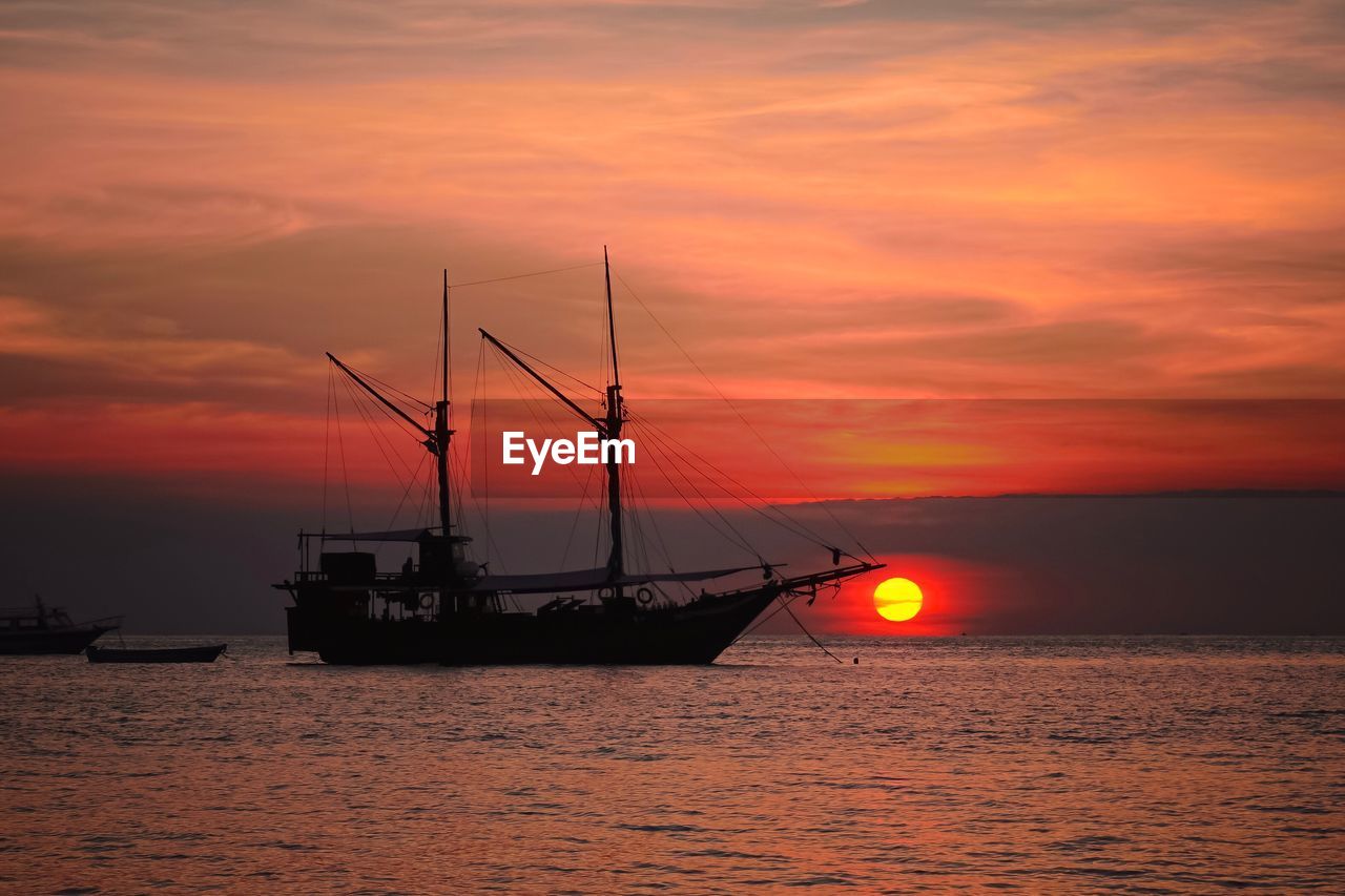 Boat on sea against sky during sunset