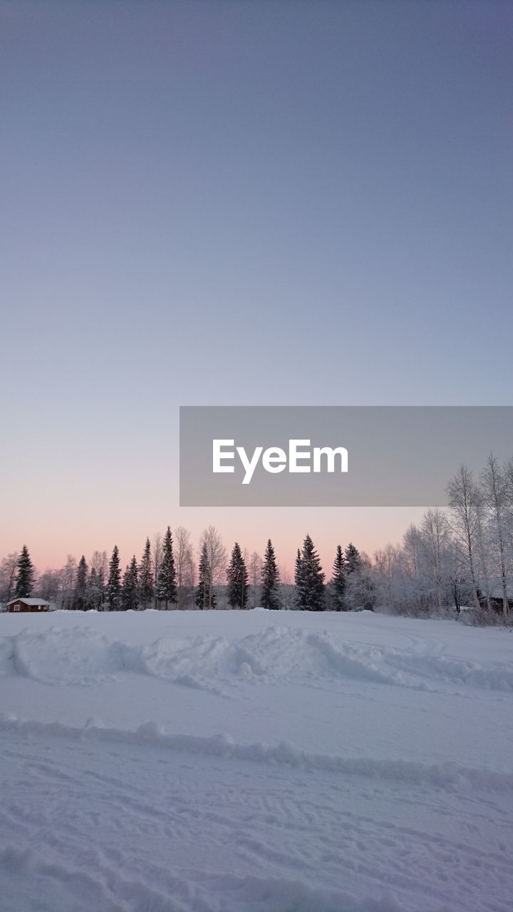 Snow covered landscape against clear sky