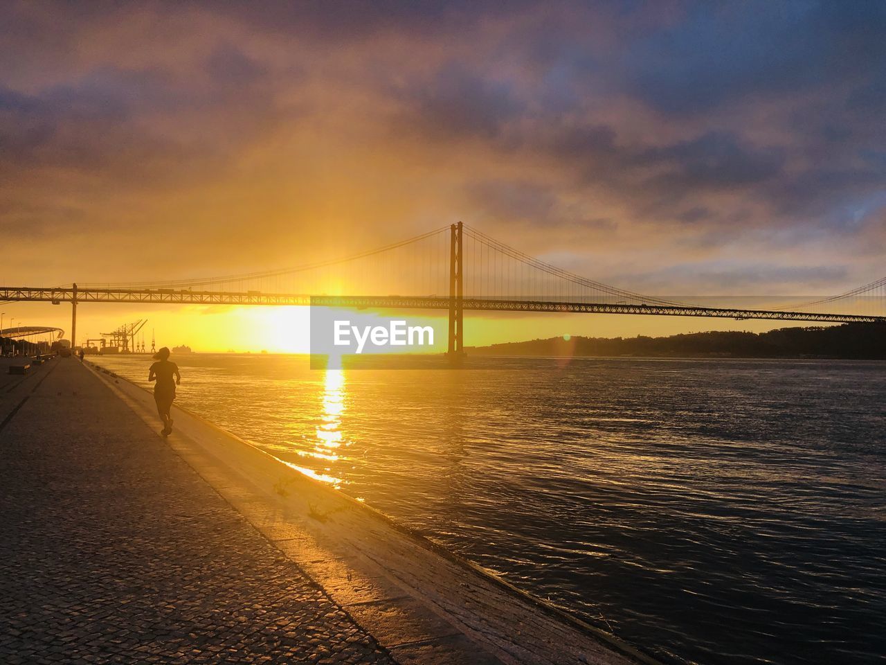 Bridge over sea against sky during sunset