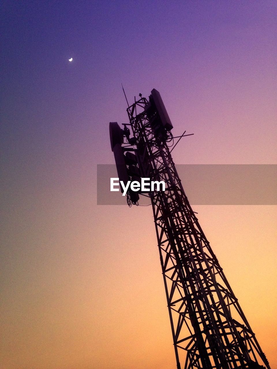 Low angle view of silhouette communication tower against sky during sunset