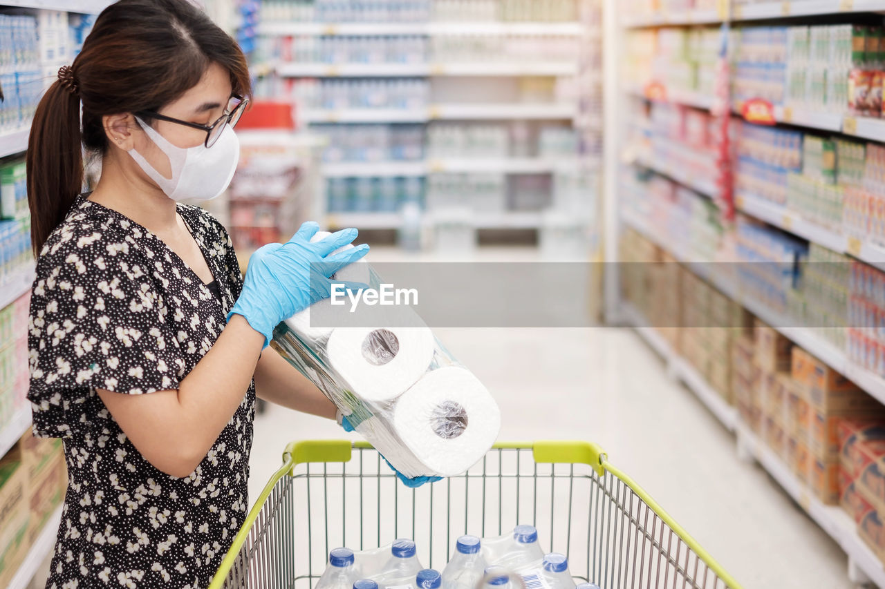 Woman holding toilet paper at shopping mall