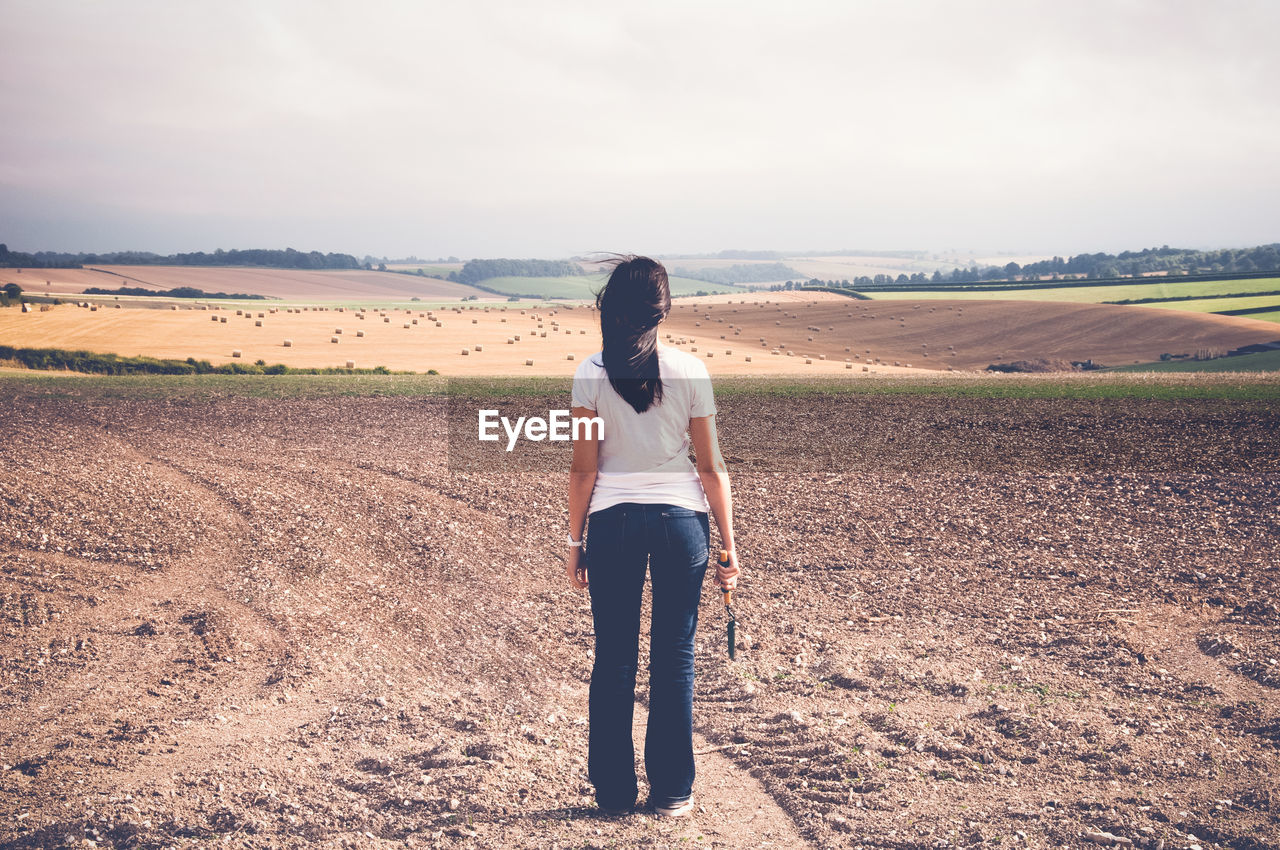 Rear view of woman standing on field