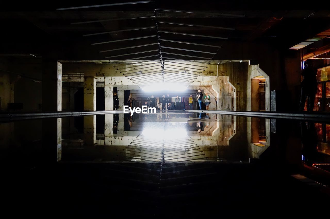 REFLECTION OF WOMAN ON ILLUMINATED MIRROR