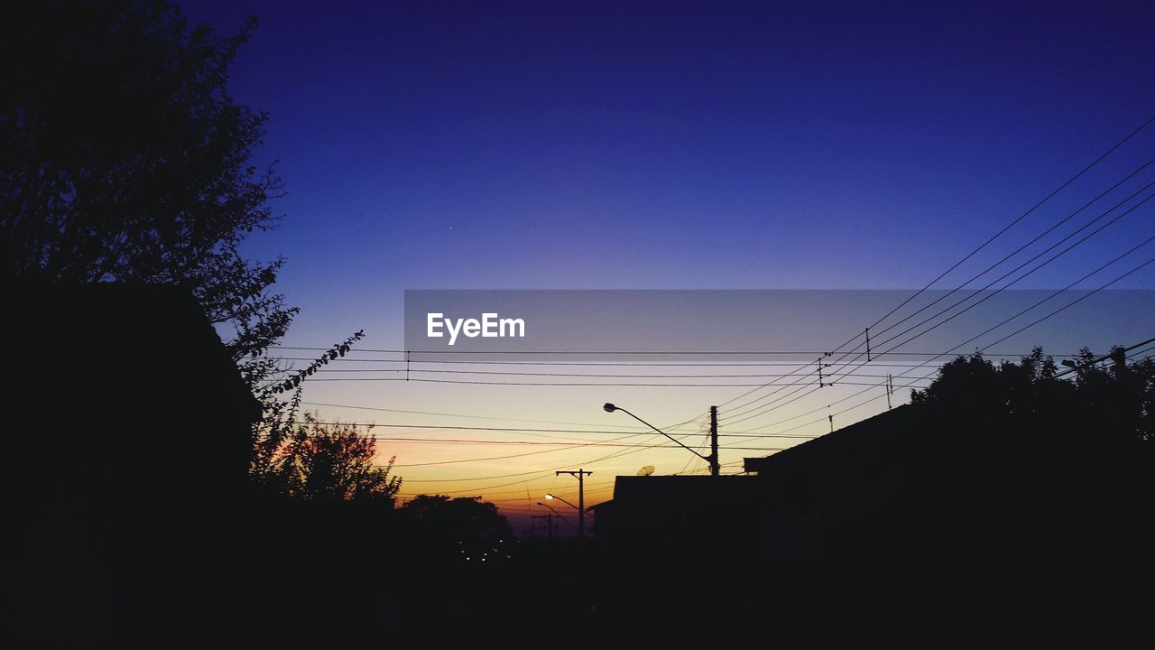 LOW ANGLE VIEW OF SILHOUETTE POWER LINES AGAINST SKY