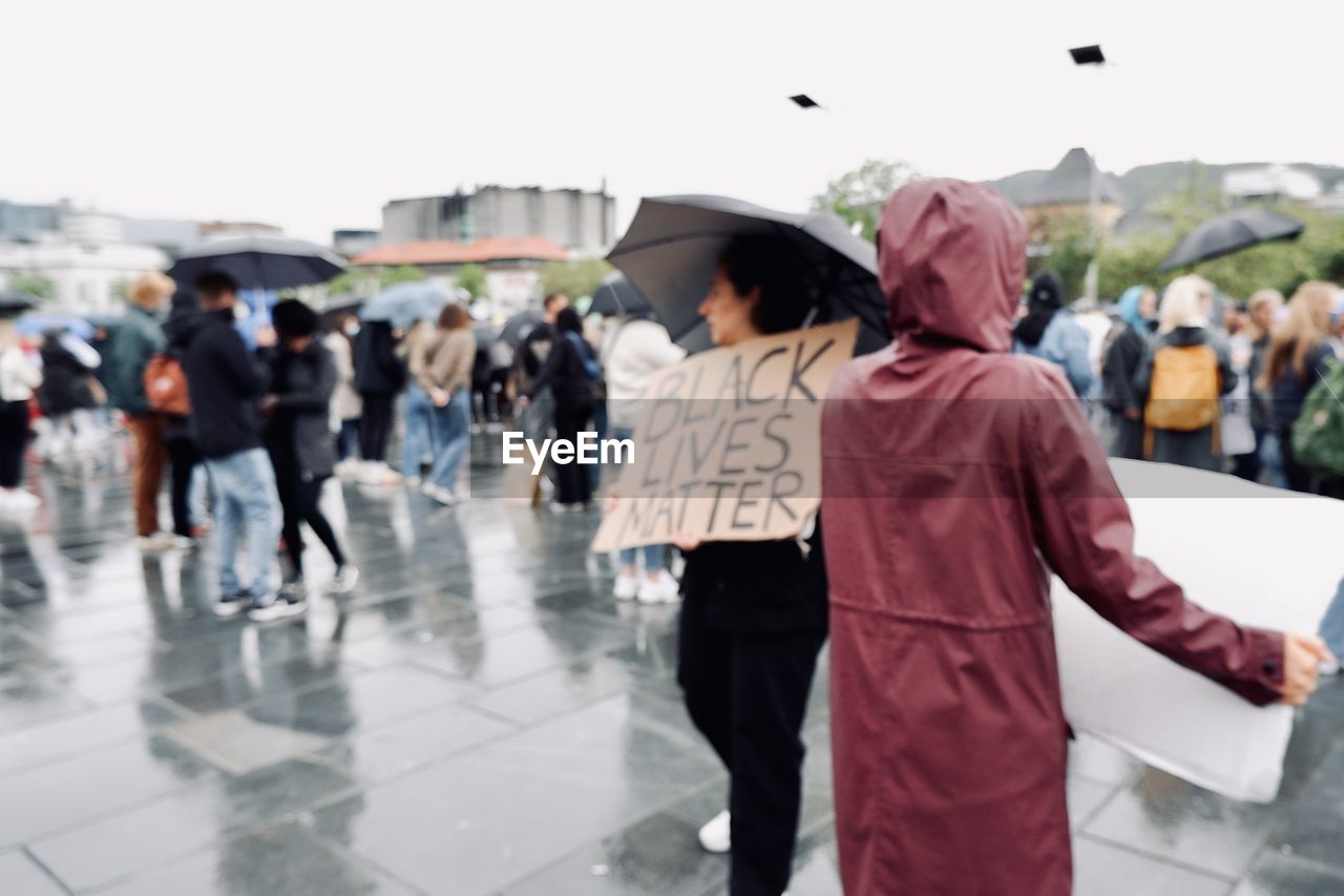 People protesting for black lives matter on wet street in city