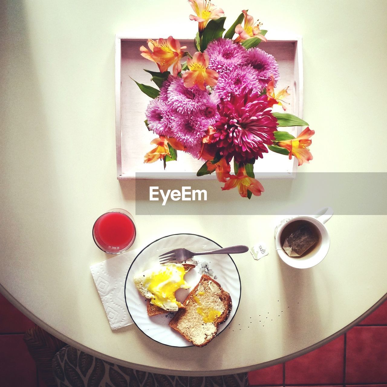 Directly above shot of breakfast by flowers on table at home